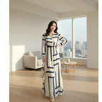Woman wearing a long, patterned dress on a white background