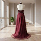 Burgundy evening gown on a mannequin against a white background