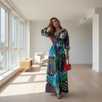 Woman in a colorful dress holding a red handbag on a city street.