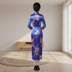Woman in a traditional floral dress standing in a room with wooden furniture and decor.